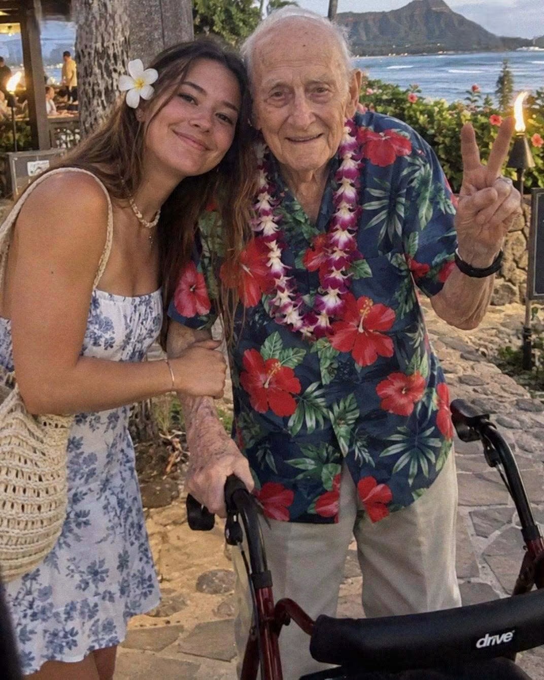 I surprised my grandfather with the trip to Hawaii he had dreamed of his entire life — on our last day there, the hotel manager said, “We’ve been looking for your grandfather for more than 80 years.” Grandpa Henry was stationed on Oahu during World War II. He survived Pearl Harbor, returned to Ohio, and met my grandmother. He always meant to go back, but life came first: Grandma Evelyn, three children, mortgages, and bills. After she died, he would trace the Pacific on a map. “Just once more,” he’d say. “I’d like to smell that ocean before I go.” I was always his girl. He taught me to drive and called every Sunday, even when his hands shook. So I saved up and bought two tickets for his dream trip. In Hawaii, Grandpa seemed young again. He let sand run through his palm, touched a banyan tree like an old friend, and stood at Pearl Harbor with Grandma’s picture pressed against his chest. We stayed at an old family-run hotel. Everything was perfect, except for one strange detail. From the moment we arrived, the staff stared at us for no obvious reason. A housekeeper dropped her towels when she saw us on our floor. The cook peered through the kitchen door while we ate. Twice, I caught the desk clerk pointing at Grandpa. “Maybe they’ve never seen an old man in a hibiscus shirt,” he joked. But on our final afternoon, while Grandpa rested upstairs, the manager stopped me. “Ma’am,” he said, his eyes wet, “we’ve searched for your grandfather for more than 80 years! We had already given up hope, but here he is.” I stepped back. “My grandfather served here when he was young, but he has never been back to Hawaii since.” “He did something I’m certain he never told you about. Please, follow me.” He unlocked a narrow room behind the lobby. It smelled of cedar and old paper. An elderly Hawaiian woman sat beside the wall. She saw me and began to cry. “You look so much like Henry,” she said through her tears. Only then did I notice what was behind her. My breath caught in my throat. “Grandpa, what have you done? How are we supposed to live with this now?” I whispered